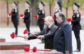  ?? — AFP photos ?? Putin (left) and Tajikistan President Emomali Rakhmon lay flowers at a memorial to the Hero Cities during a ceremony at the Tomb of the Unknown Soldier after the Victory Day military parade in Moscow.