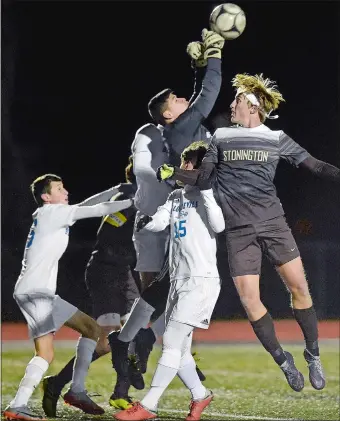  ?? SARAH GORDON/THE DAY ?? Plainville goalkeeper Sergio Zalvidar reaches high to punch away a shot on goal by Stonington’s Graham Johnstone, right, during Wednesday’s CIAC Class M boys’ soccer tournament semifinal at Xavier High in Middletown. Plainville ended the Bears’ season with a 2-1 win. Visit theday.com to view a photo gallery.