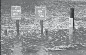  ?? Westside Eagle Observer/MIKE ECKELS ?? Two signs and a telephone junction box were under a foot of water at Crystal Lake Park in Decatur on March 27.