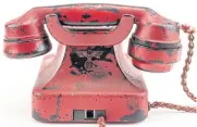  ??  ?? Undated handout photos show a red telephone once owned by German dictator Adolf Hitler. The back of the phone is embossed with a swastika and the eagle symbolic of the Third Reich.