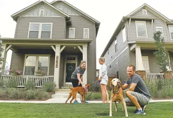  ?? Helen H. Richardson, The Denver Post ?? Stapleton residents Heather Calhoun, left, chats with her neighbors Trinity and Chuck Simmons, right, while they walk their dogs in their Beeler Park neighborho­od on Wednesday.