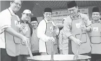  ??  ?? BUBUR LAMBUK: Abang Johari (tengah) menguar bubur lambuk sebagai simbolik perasmian. Turut kelihatan Sardon (kiri) dan Dr Abdul Rahman (dua kanan).