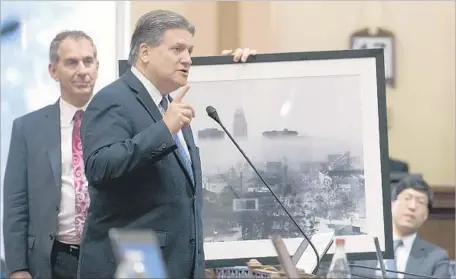  ?? Rich Pedroncell­i Associated Press ?? STATE SEN. Bob Hertzberg (D-Van Nuys), center, calls for passage of Assembly Bill 398 as Sen. Bob Wieckowski (D-Fremont), left, holds a 1966 photo of smog over L.A. The legislatio­n to extend cap and trade passed 55 to 21 in the Assembly and 28 to 12 in...