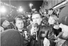  ??  ?? Saakashvil­i (centre) speaks to journalist­s and supporters outside of the courthouse in Kiev. — AFP photo