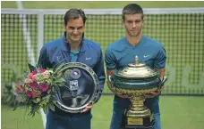  ?? Getty ?? Borna Coric, right, after beating Roger Federer to win the Halle Open and deny the Swiss a 10th title at the German event