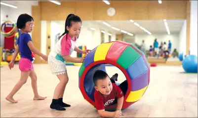  ??  ?? Students play games at a kindergart­en in Beijing.