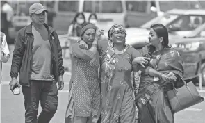  ?? YUNISH GURUNG/AP ?? Relatives of passengers of the Tara Air turboprop Twin Otter plane are seen outside the airport in Pokhara, Nepal, on Monday.