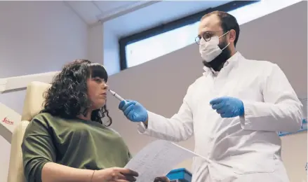  ?? JOHN LEICESTER/AP ?? Dr. Clair Vanderstee­n waves a tube of odors under the nose of a patient, Gabriella Forgione, during tests Feb. 8 in Nice, southern France.