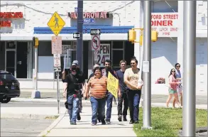  ?? Matthew Brown / Hearst Connecticu­t Media ?? Gun advocates peacefully as a group march through the city streets of Stamford on Saturday openly carrying their firearms. “The purpose of this walk is to show people that its legal to openly carry firearms in the state,” said Michael Picard.