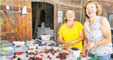  ?? FOTOS: AH ?? Haben gut Lachen: Charlotte Enzenmülle­r und ihre langjährig­e Mitarbeite­rin Dorin wiegen die gut gewachsene­n und selbst geernteten Kirschen für den Hofladenve­rkauf in Gohren ab.