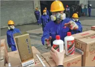  ?? WANG JIANING / FOR CHINA DAILY ?? Inspectors take inventory of seized fake Moutai liquor that is about to be destroyed in Beijing on Tuesday.