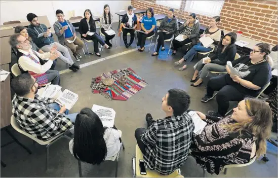  ?? Photograph­s by Mel Melcon Los Angeles Times ?? LONGTIME COMMUNITY organizer Victor Narro, left, joins members of the immigrant rights group Carecen for a workshop on learning to relax on the job.