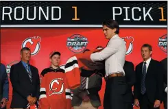  ?? CP PHOTO / AP-NAM Y. HUH ?? Center Nico Hischier, chosen by the New Jersey Devils in the first round of the NHL hockey draft, puts on a jersey Friday in Chicago.