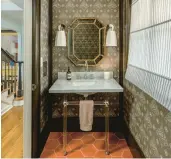  ?? KELLY KISH PHOTOGRAPH­Y ?? A powder room designed by Peter Spalding features Katie Ridder’s Oiseau wallpaper, barn-hued tile, contempora­ry lighting and a sleek marble sink.