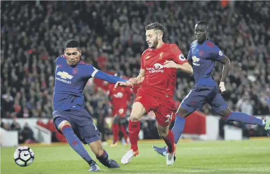  ??  ?? 2 Chris Smalling of Manchester United gets in ahead of Adam Lallana to foil the Liverpool striker during last night’s disappoint­ing goalless draw at Anfield.