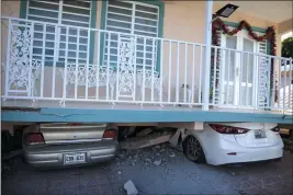  ?? CARLOS GIUSTI — THE ASSOCIATED PRESS ?? Cars are crushed under a home that collapsed after an earthquake hit Guanica, Puerto Rico, on Monday.