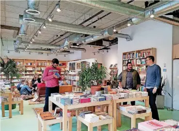  ?? [PHOTO BY STEVE LACKMEYER, THE OKLAHOMAN] ?? Chris Castro and Benjamin Nockels, far right, discuss plans for expansion of Commonplac­e Books into an adjoining space where Castro will operate the bookstore cafe.