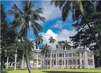  ?? Photog r aphs by Kent Nishimura Los Angeles Times ?? SURF’S UP at Kahanamoku Beach in Waikiki, top. Iolani Palace, residence of the rulers of the kingdom of Hawaii, above, is operating at reduced capacity.