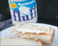  ?? "1 1)050 ?? In this Sept. 27, 2013, photo, a jar of Marshmallo­w Fluff and a Fluffernut­ter sandwich are displayed in North Andover, Mass.