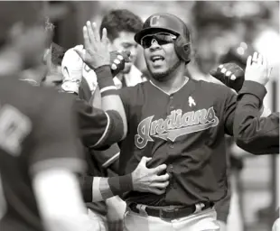  ?? AP ?? Edwin Encarnació­n, de los Indios, es felicitado por sus compañeros tras haber dado un cuadrangul­ar solitario en el partido contra Detroit.