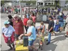  ??  ?? People line up Monday to buy ice in Wilmington, N.C.