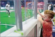  ?? SARAH GORDON/THE DAY ?? Reagan Pierce, 12, of East Lyme pounds on the plexiglass as he watches a Black Wolves game.