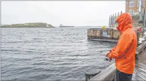  ?? CHRONICLE HERALD PHOTO ?? A man fishes on the Halifax waterfront despite the rain on August 19, 2017. We may be spared the aftermath of a hurricane, but that won’t keep us dry.