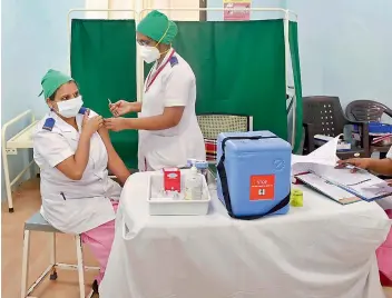  ?? — PTI ?? A medic vaccinates a healthwork­er with Covishield vaccine during a countrywid­e inoculatio­n drive against Coronaviru­s, at Rajawadi Municipal Hospital in Mumbai on Tuesday.