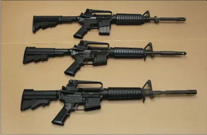  ?? AP PHOTO/RICH PEDRONCELL­I,FILE ?? FILE -- In this Aug. 15, 2012file photo, three variations of the AR-15assault rifle are displayed at the California Department of Justice in Sacramento, Calif. While the guns look similar, the bottom version is illegal in California because of its quick reload capabiliti­es.