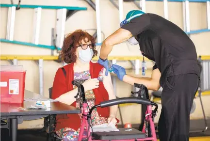  ?? JARROD VALLIERE U-T ?? Rochelle Kern receives her first dose of the coronaviru­s vaccine from registered nurse Dominic Camarda at the Gary and Mary West Senior Wellness Center in downtown San Diego on Friday.