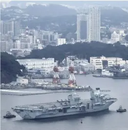  ??  ?? Above: The HMS Queen Elizabeth is seen sailing toward the U.S. Navy’s base in Yokosuka, Kanagawa Prefecture, on Saturday. Right: Carrier-based aircraft are lined up on the flight deck of the HMS Queen Elizabeth as it heads for the Yokosuka base.