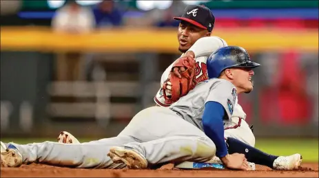  ?? PHOTOS BY CURTIS COMPTON / CCOMPTON@AJC.COM ?? Dodgers center fielder Enrique Hernandez collides with Braves second baseman Ozzie Albies as Hernandez steals second base in the seventh inning of Game 4 of their National League Division Series on Monday in Atlanta.