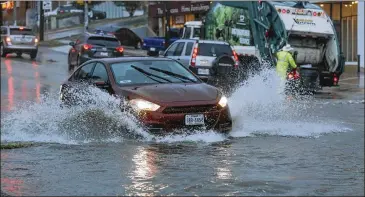  ?? JAMES GREGG / AMERICAN-STATESMAN ?? Vehicles plow through high water Friday that accumulate­d on North Lamar Boulevard in downtown Austin as powerful storms swept through the area. Camp Mabry recorded 3.65 inches of rain.