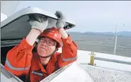  ?? ZHAO GE / XINHUA ?? Mao Jun, a Xinjiang Goldwind Science & Technology Co technician, checks a turbine at a wind farm in Urumqi, the Xinjiang Uygur autonomous region.