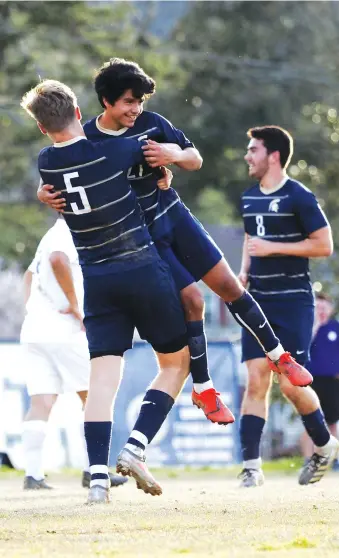  ?? STAFF PHOTO BY C.B. SCHMELTER ?? Soddy-Daisy’s Chandler Hartman (5) picks up teammate David Lopez after Lopez scored a goal against Temple on Friday. Hartman helped his team win 4-0 to start their Trojan Invitation­al, a 14-team event.