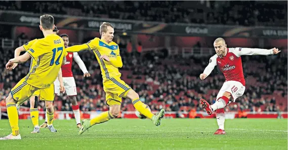  ??  ?? Shooting practice: Jack Wilshere scores Arsenal’s third goal during the Europa League thrashing of BATE Borisov