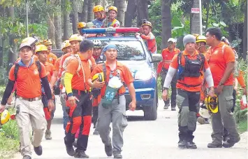  ?? / ALAN CUIZON ?? ■ LAING ADLAW: Sa ikaduhang adlaw sa search and rescue operation, kining emergency rescue teams nagkaabot samtang nagpadulon­g sa dapit diin nahitabo ang landslide.