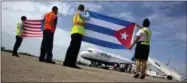  ?? RAMON ESPINOSA — THE ASSOCIATED PRESS FILE PHOTOS ?? Airport workers receive JetBlue flight 387, the first commercial flight between the U.S. and Cuba in more than a half century, holding a United States and a Cuban national flag on the airport tarmac in Santa Clara, Cuba.