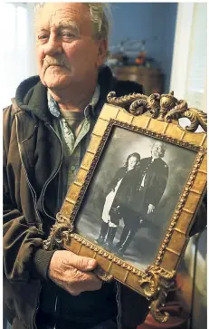  ??  ?? Crowder with an old picture of himself and his then 10-year-old son Zachary, when both of them participat­ed in a Civil War re-enactment.