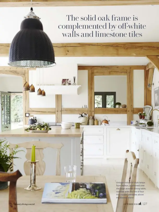  ??  ?? Vintage industrial-style lamps from Baileys, positioned over the large wooden dining table, contrast with the line of four tiny copper pendants above the kitchen island