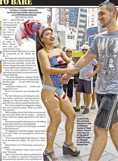  ??  ?? A painted topless performer attempts to stop a pedestrian Sunday in Times Square. There is a growing call for the city to rein in the women who pose for photos and demand tips.