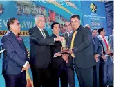  ??  ?? Wijaya Products Managing Director Aruna Kothalawal­a receiving the award from Prime Minister Ranil Wickramasi­nghe