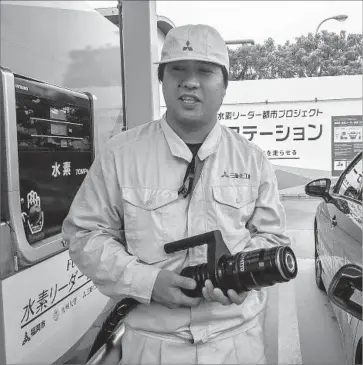  ?? Photograph­s by Julie Makinen Los Angeles Times ?? AN ATTENDANT fills a Toyota Mirai in Fukuoka, Japan, where biogas from a sewage treatment plant is being converted into hydrogen. Japan is in the midst of a major push to get hydrogen-fueled cars on the road.