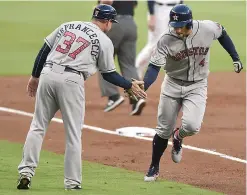  ?? AP Photo/Richard Hamm ?? Houston Astros' George Springer celebrates a run with Astros Triple-A manager Tony DeFrancesc­o during the third inning of a baseball game against the Atlanta Braves on Tuesday in Atlanta, Ga.