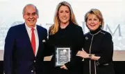  ??  ?? Rising Star award recipient Melissa McAnelly, center, is congratula­ted by John A. Daugherty Jr. and Cheri Fama.