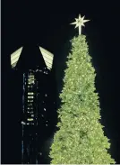  ?? [PHOTOS BY SARAH PHIPPS/ THE OKLAHOMAN] ?? A Christmas tree at Scissortai­l Park stands against the backdrop of downtown's largest tower, the 50-story Devon Energy Center.