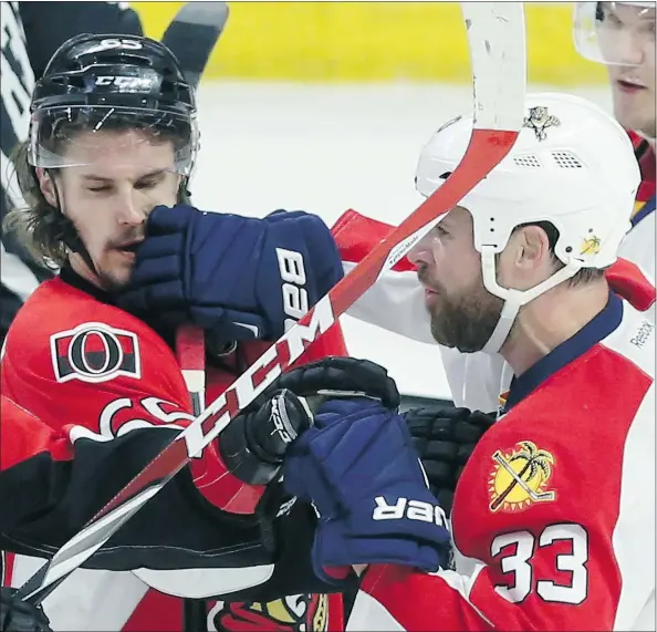  ??  ?? Ottawa Senators’ Erik Karlsson, left, and Florida Panthers’ Willie Mitchell tangle during Sunday’s game in Ottawa.