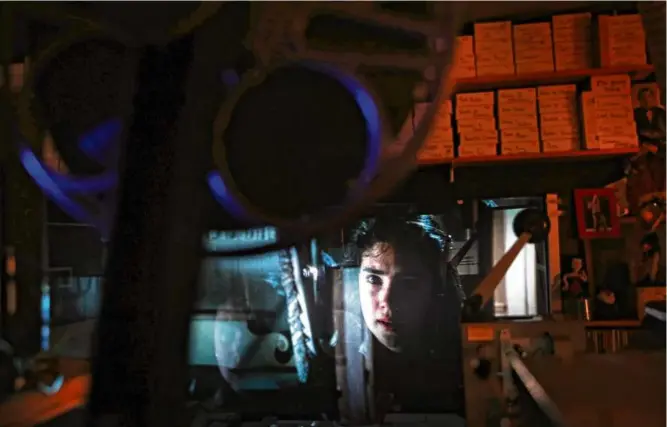  ?? CRAIG F. WALKER/GLOBE STAFF ?? A scene from “Labyrinth,” starring Jennifer Connelly, reflected on glass in the projection booth at the Brattle Theatre in Cambridge in April 2022.