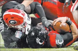  ?? Brynn Anderson The Associated Press ?? Defensive tackle Devonte Wyatt records one of Georgia’s program record-tying eight sacks of Cincinnati quarterbac­k Desmond Ridder in the Bulldogs’ 24-21 win in the Peach Bowl on Friday at Mercedes-benz Stadium.