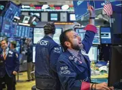  ?? DREW ANGERER / GETTY IMAGES ?? Traders and financial profession­als work at Friday’s opening bell on the floor of the New York Stock Exchange at the end of a rough week.